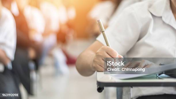 Exam With School Student Having A Educational Test Thinking Hard Writing Answer In Classroom For University Education Admission And World Literacy Day Concept Stock Photo - Download Image Now