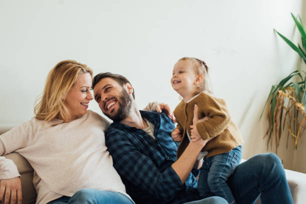 istock Couple in love looking at each other while holding a child 963195768
