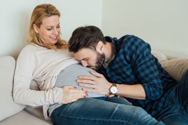 istock Man kissing pregnant woman's belly 963196288
