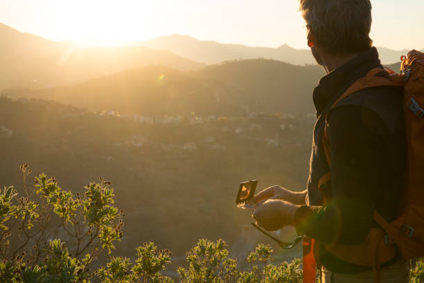 Male hiker wanders through hills in sunlight