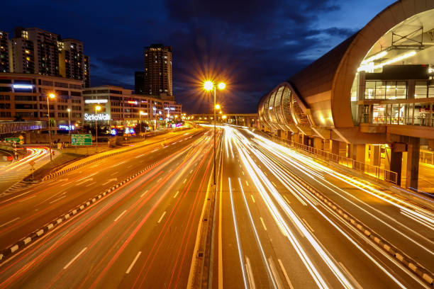 istock Light Trails On Road Amidst Buildings In City At Night 963201272