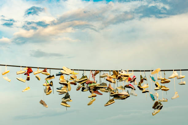 Old Shoes hanging on electrical wire against a sky