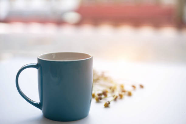 istock The blue ceramic coffee cup ,on white desk,warm light tone,blurry light around. 963205592