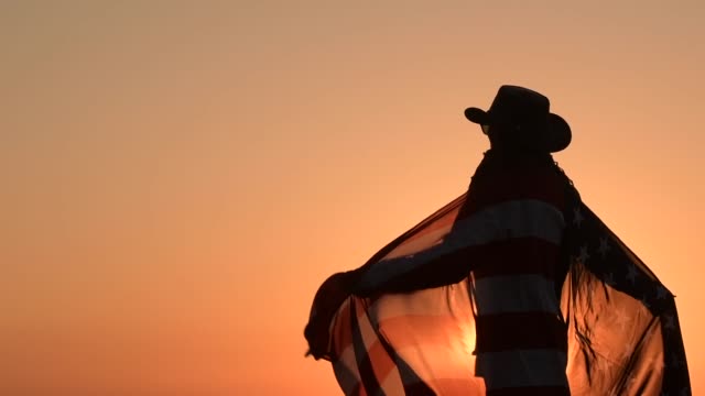 Cowboy Playing with American Flag During Scenic Sunset. Independence Day Celebration
