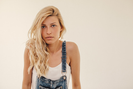 Portrait of a cute blonde girl wearing overalls