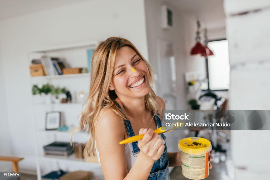 House painting in progress Portrait of a young smiling woman painting her house all by herself Painting - Activity Stock Photo