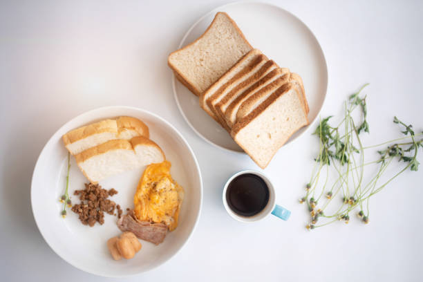 The breakfast dish.scramble,ham,sausage and sliced bread,on white desk,