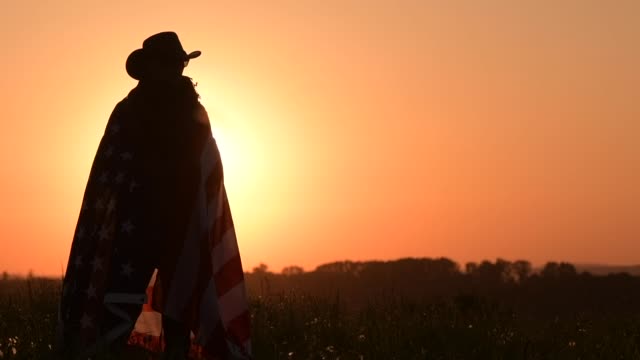 Western Wear Caucasian Men with United States Flag in Hands. Scenic Sunset. Slow Motion Footage