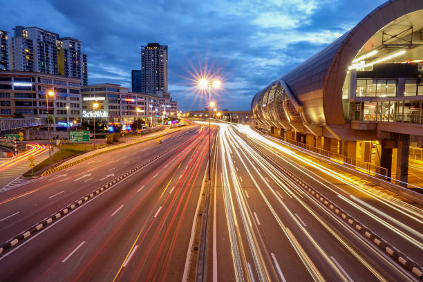 istock Light Trails On Road Amidst Buildings Against Sky At Night 963251318