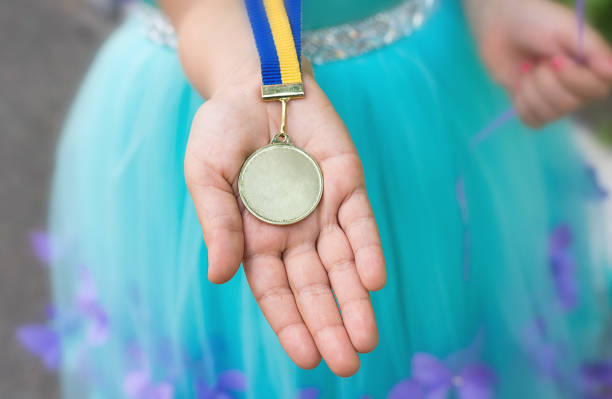 Gold medal at girl hand. Graduated from kindergarten