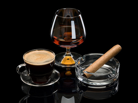 Cognac, coffee, cigar in glassware it is isolated on black