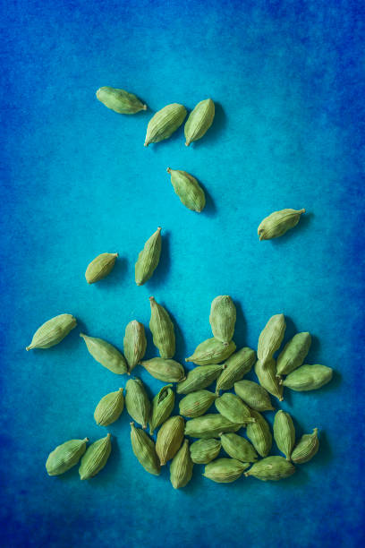 Green cardamom fruit Green cardamom fruit on blue surface cardamom stock pictures, royalty-free photos & images