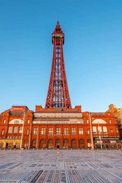 Blackpool Tower and Entrance A man stands in front of the Blackpool Tower building with writing on the floor, on a sunny afternoon. Blackpool Tower stock pictures, royalty-free photos & images