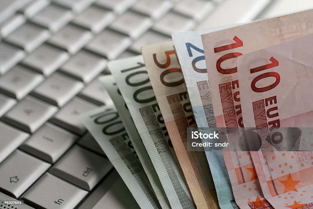 Billets Euro sur un ordinateur portable - Photo de Acheter libre de droits