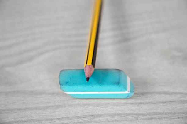 Erasers and pencil on yellow background, closeup