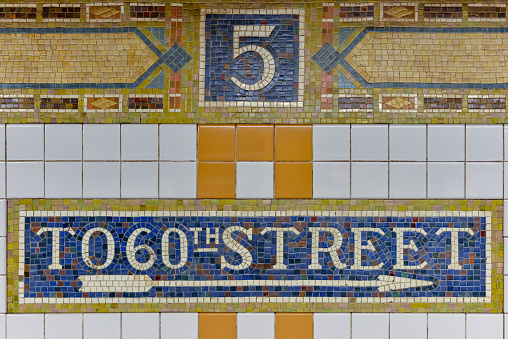 NEW YORK, NEW YORK - OCTOBER 27, 2014: Classic mosaic tile of the Fifth Avenue Subway Station, New York. Sign showing exit to 60th Street.