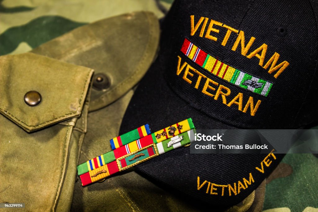 Vietnam Veterans Hat, Service Ribbons & Pouches Vietnam Veterans Hat, Service Ribbons & Pouches On Camouflage Uniform Veteran Stock Photo