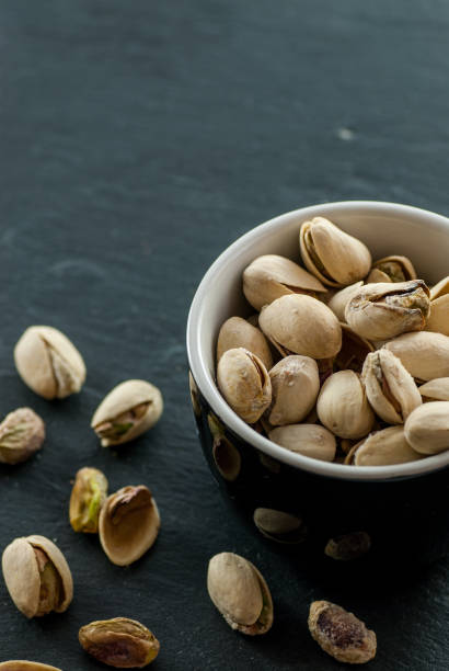 istock bowl with roasted pistachio on a black slate with copy space 963299220