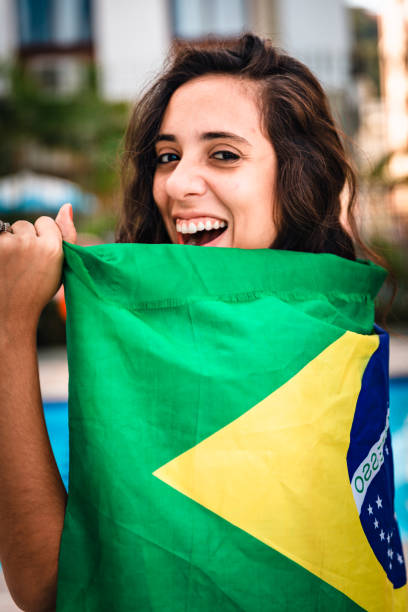 istock Young woman embracing Brazilian flag 963336690