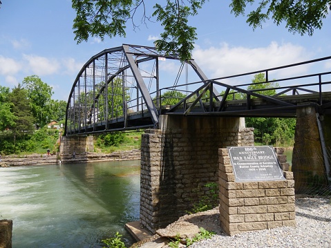 Bridge over the War Eagle Mill river with a commemorative marking for the 100th anniversary of the bridge in Rogers, Arkansas.