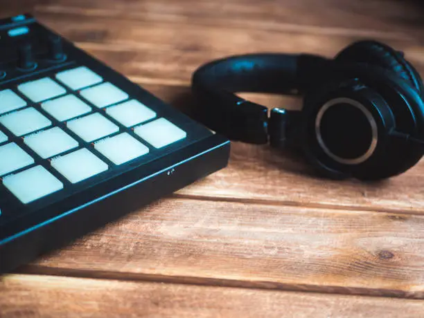 Photo of making music concept, pads and headset on a wooden surface