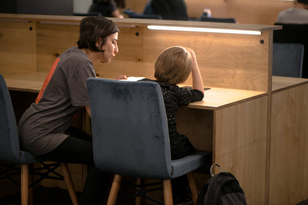 istock Little Boy With His Mother In Library 963342708