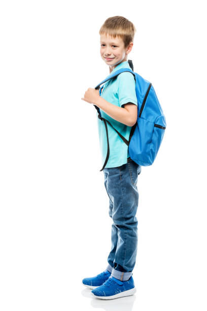 istock portrait of a schoolboy with a backpack side view on a white background in full length 963347408