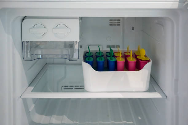 Classic popsicle mold set in freezer container for homemade ice lolly in summer. stock photo
