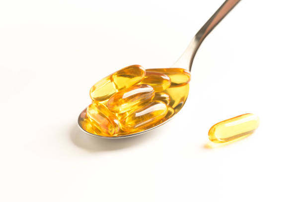 istock fish oil capsules in a spoon on white background 963351814