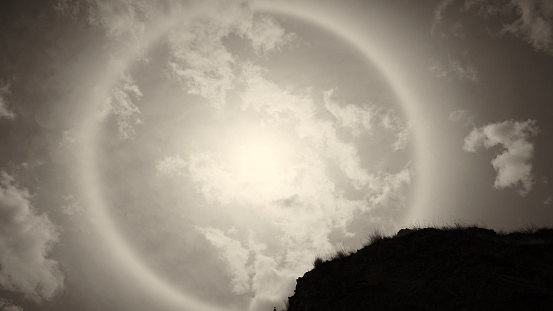 Sun halo white some rock and tree branches on the sunny day with sepia tone