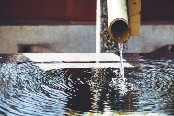 Photo of Bamboo fountain in a traditional Japanese Zen garden, chozuya or temizuya,