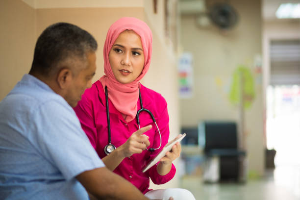 Female Muslim Doctor consulting with a patient Female Muslim Doctor consulting with a patient indonesian ethnicity stock pictures, royalty-free photos & images
