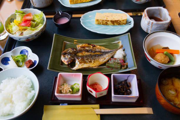 istock Japanese breakfast dishes including cooked white rice, grilled fish, fried egg, miso soup, other side dishes 963363130