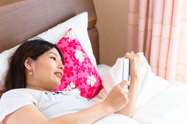 istock Pregnant woman seeing tablet in bed 963382878