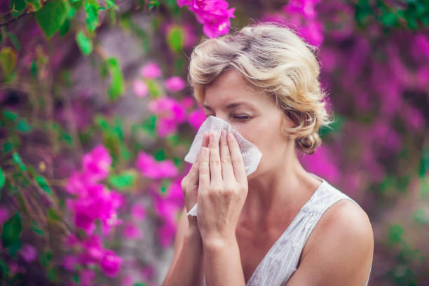 istock Woman with with allergy symptom blowing nose 963382998