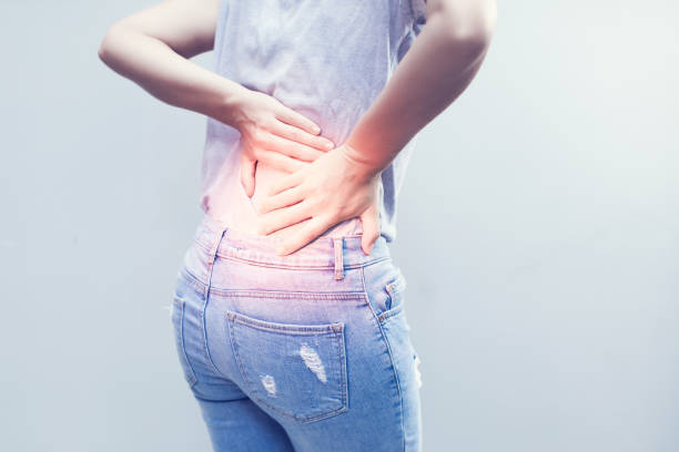 istock Portrait of young woman touching her back with pained expression, suffering from backache after long working hours, Healthy concept. 963383022