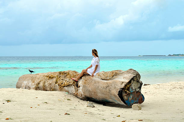 istock woman sitting on the tropical beach 96338345