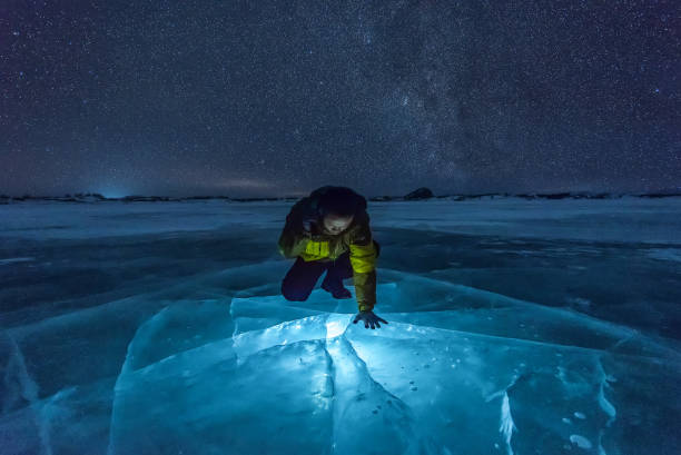 Milky Way on Ice Lake in Winter Grassland