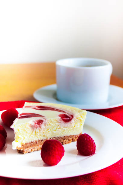 Close up of raspberry cheesecake and hot drink