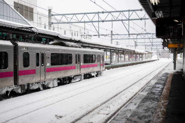 rosa streifen jr east 701-serie commutor zug in hirosaki station im winter trainieren emu alarmkontakt auf ou hauptlinie zwischen akita und aomori - opperated stock-fotos und bilder