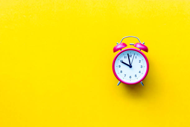 istock A red alarm clock with ten o'clock on yellow  background with copyspace 963396018