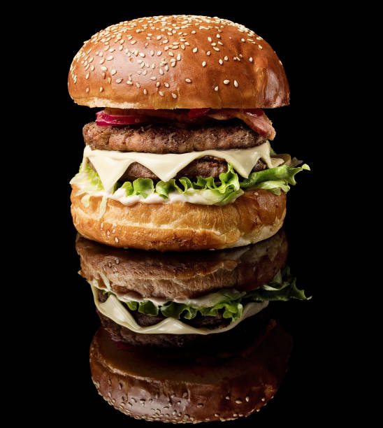 istock big fat burger with fresh vegetables with reflection isolated on black background 963403512