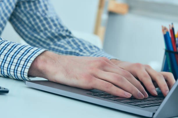 istock Male hands typing on laptop keyboard. Young man using laptop computer. Business working concept 963410892