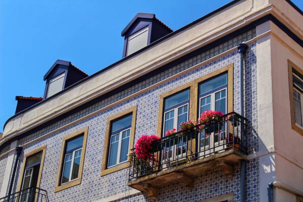 Old colorful and tiled facades with vintage streetlight in Lisbon streets in Spring. Clothesline in the facade with hanging clothes