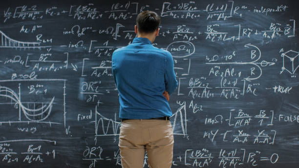 brillante junge mathematiker ansätze große tafel und denkt über lange und komplexe gleichung / formel. - physics classroom teaching professor stock-fotos und bilder