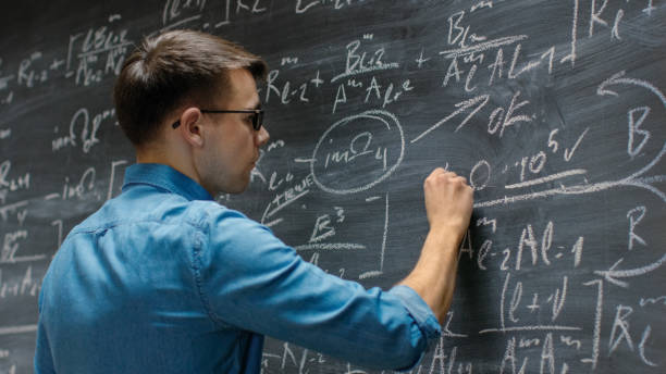 istock Brilliant Young Mathematician Approaches Big Blackboard and Finishes writing Sophisticated Mathematical Formula/ Equation. 963424214