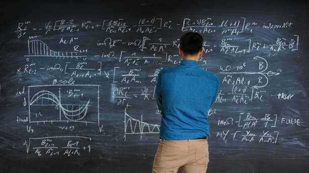 istock Brilliant Young Mathematician Approaches Big Blackboard and Thinks about Solving Long and Complex Equation/ Formula. 963424216