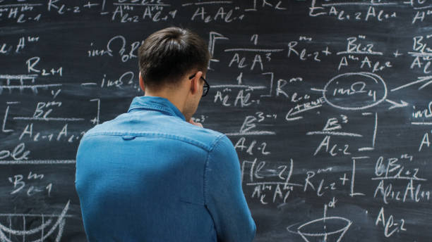 istock Brilliant Young Mathematician Approaches Big Blackboard and Thinking about Sophisticated Mathematical Formula/ Equation. 963424234