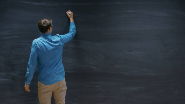 istock Shot of a Man Starting to Write on the Blackboard. Empty Chalkboard Perfect for Template. 963424258