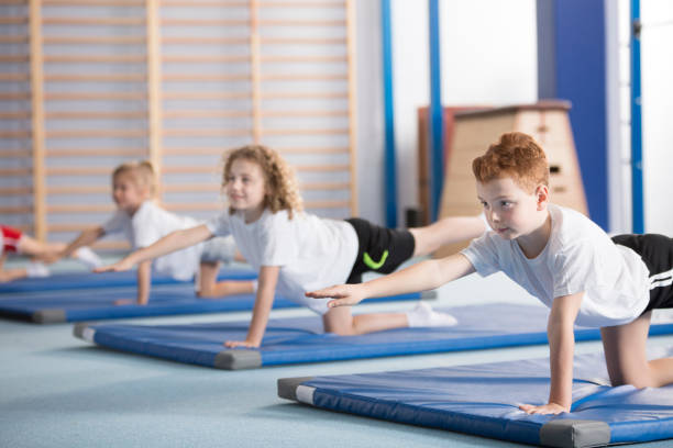 posent des enfants, exercice d’yoga équilibre - éducation physique photos et images de collection